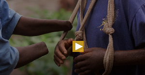 An amputee helps another place a sling on his functionless hands
