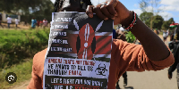 A protester holds up a placard during a demonstration against a proposed Ebola quarantine center