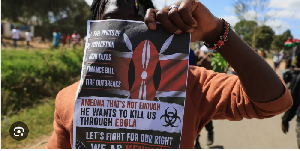 A protester holds up a placard during a demonstration against a proposed Ebola quarantine center
