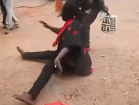 The female relative of the deceased immigration officer sitting on the floor invoking curses