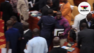 Sam George being restrained by other minority members in Parliament on Thursday
