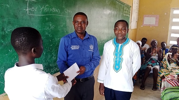 A representative of the church presenting the money to the student