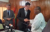 Alex Segbefia exchanging the grant agreement with Marcel Lantinga