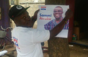 An NPP supporter pasting Sammi Awuku