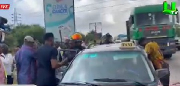 Kwasi Amoako-Atta (in cap) and others helping the victim into a taxi