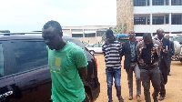 The three accused persons being escorted out of the court premises