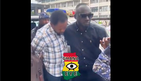 Suspect Bright Aweh with his gaze partially lowered while being ushered into court