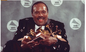 Quincy Jones cradles his Grammy awards, including the album of the year award