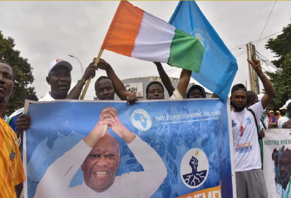 Waving Ivory Coast’s national flag, protesters brandish a banner of PPA-CI leader Laurent Gbagbo