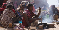 A girl prepares food at a displacement camp in El Fasher, North Darfur region, Sudan on July 9, 2025