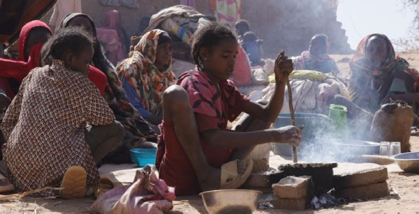 A girl prepares food at a displacement camp in El Fasher, North Darfur region, Sudan on July 9, 2025