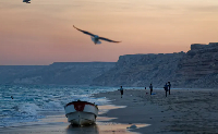 Fishermen stand on the Indian Ocean beach at dusk in the former pirate village of Eyl