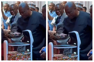 A robot handing over Ghana's National Artificial Intelligence Strategy document to President Mahama