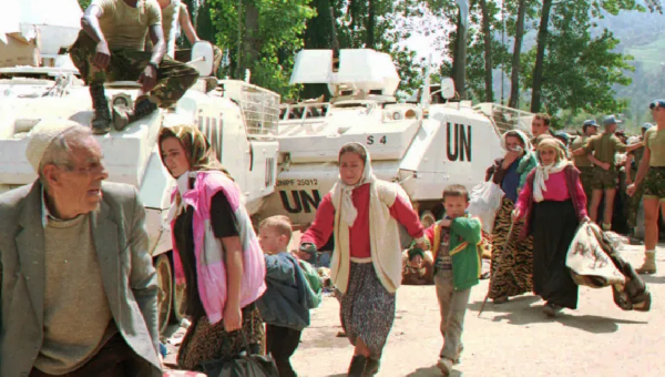 Srebrenica refugees pass UN vehicles in Potocari, Bosnia