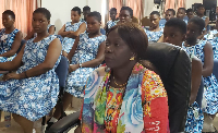 A woman is seen seated with students