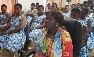 A woman is seen seated with students