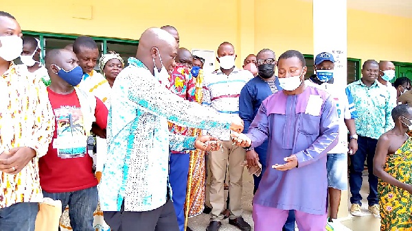 Municipal Chief Executive of Lower Manya Krobo, Simon Kweku Tetteh handing over the keys