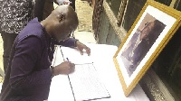 Sports Minister Vanderpuye signing a book of condolence at the residence of the late Koufie