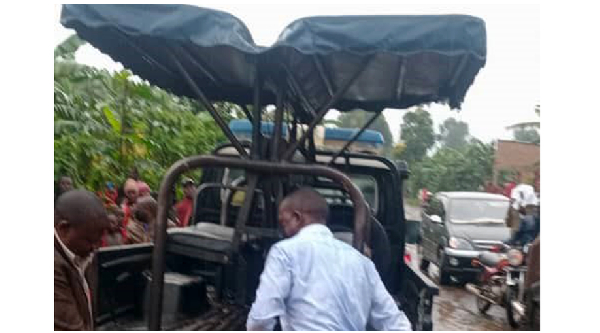 Police officers load the body of the deceased in Masaka village