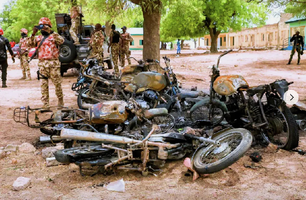 A soldier takes photos of burned motorbikes in Guyaku, northeastern Nigeria, Monday, April 27, 2026