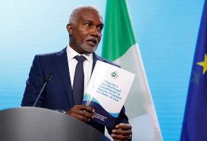 Nigerian Foreign Minister Yusuf Tuggar displays a document about his country's commitment