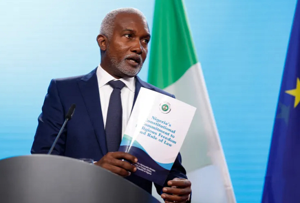 Nigerian Foreign Minister Yusuf Tuggar displays a document about his country's commitment