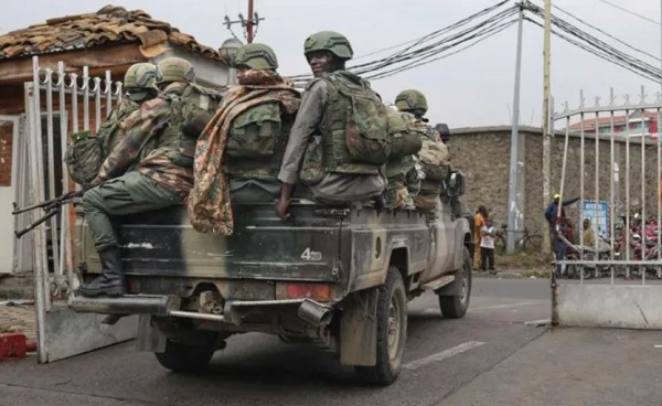 Members of the M23 rebel group mount their vehicles after the opening ceremony