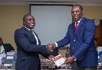 Mr Ebenezer Akyeampong of Heritage Bank presenting a copy of the book to Education Minister