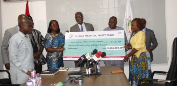 Prof. Adanu [middle] presenting the dummy cheque to Ms Darko -Opoku [fourth from left]