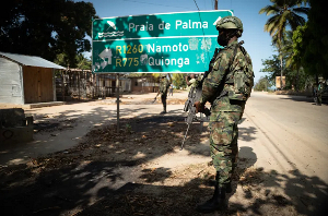 A soldier walks in front of a burned truck near Palma, Cabo Delgado province, Mozambique