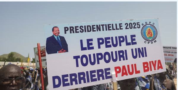 Supporters of Paul Biya, seeking an eighth term, hold a sign during the launch of his campaign