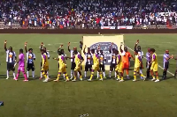 TP Mazembe players raise their right hands in a ritual symbolising unity with their supporters
