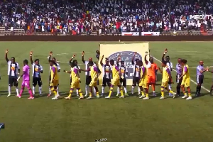 TP Mazembe players raise their right hands in a ritual symbolising unity with their supporters
