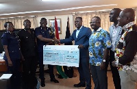 Eric Asubonteng and his team presenting the cheque to IGP David Asante Apeatu and some POMAB members
