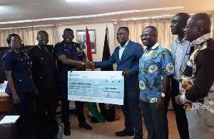 Eric Asubonteng and his team presenting the cheque to IGP David Asante Apeatu and some POMAB members