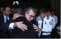 Guatemalan President Bernardo Arevalo comforts the relative of one of the police officers killed