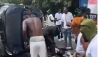 Bystanders assist victims lying near the wreckage as emergency support is sought