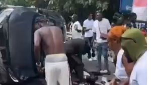 Bystanders assist victims lying near the wreckage as emergency support is sought