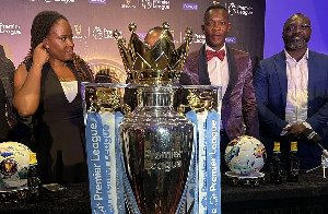 John Paintsil, John Mensah standing behind the Premier League trophy