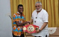 Commey presenting the title to former President Rawlings