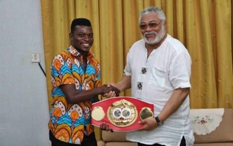 Commey presenting the title to former President Rawlings