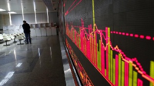 China Stocks Slump, Man Looks At Stock Exchange Board. Reuters