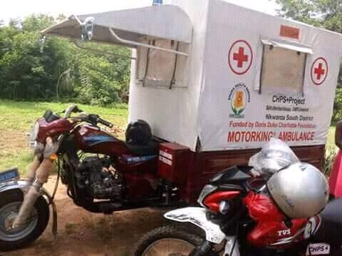 A tricycle branded and being used as an ambulance