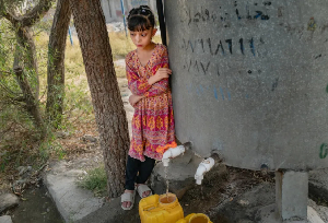 A girl fills canisters of water from a tap with non-potable water to use at home