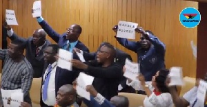 Some members of the minority holding up papers with the inscription 'Wahala Budget' in protest
