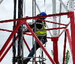 An engineer working on a cell tower to strengthen connectivity