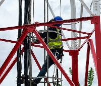 An engineer working on a cell tower to strengthen connectivity