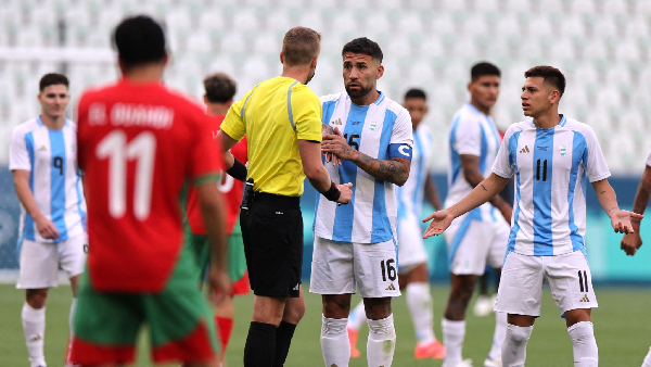 Referee Glen Nyberg speaking with Argentina captain Nicolas Otamendi