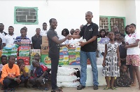CEO of Origin8, William Ansah (R) presenting the items to Moses Lamptey, a manager at the orphanage
