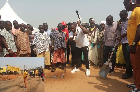 Commey, with pick axe performing the ceremonial ground breaking, while the other dignitaries look on